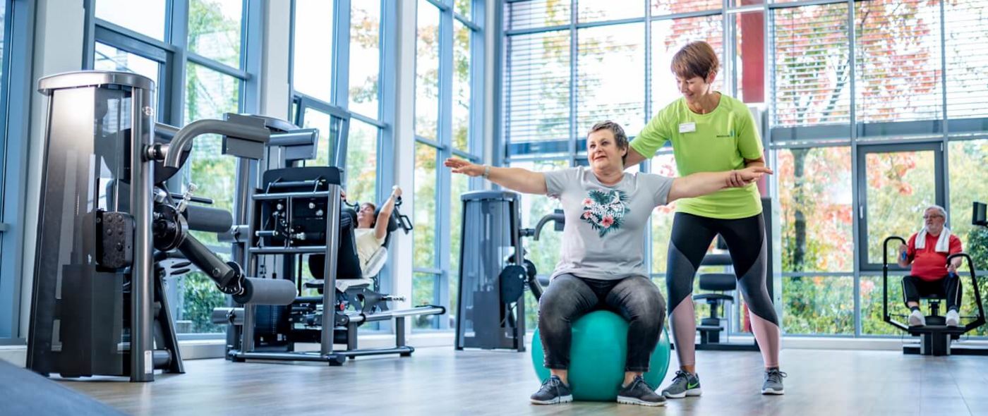 Therapeutin unterstützt Patientin in der Sporttherapie