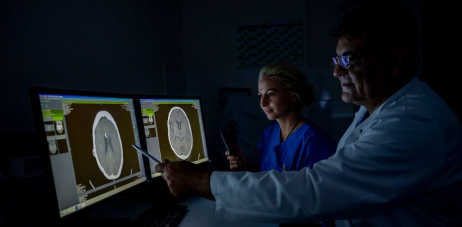 Ärzte analysieren am Monitor bildgebende Aufnahmen eines menschenlichen Schädels