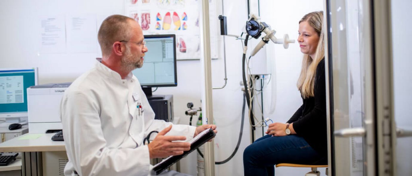 Arzt spricht mit Patientin über die Ergebnisse einer Lungenfunktionsprüfung