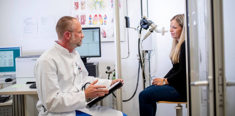 Arzt spricht mit Patientin über die Ergebnisse einer Lungenfunktionsprüfung