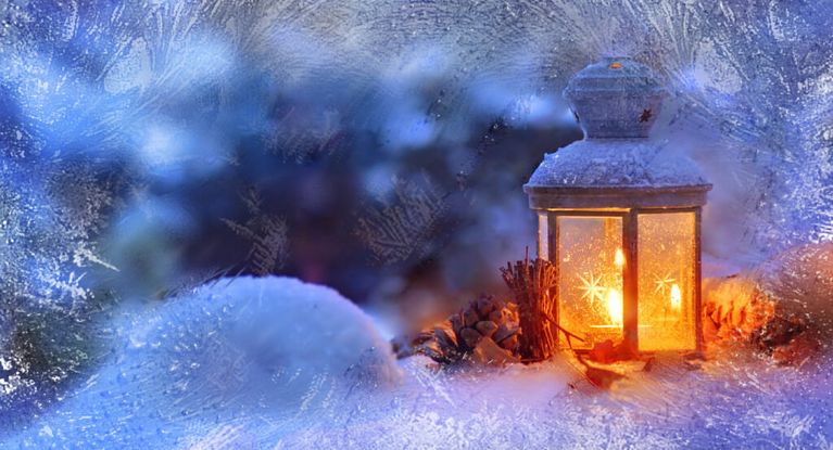 Weihnachtliche Laterne leuchtet in einer Schneelandschaft