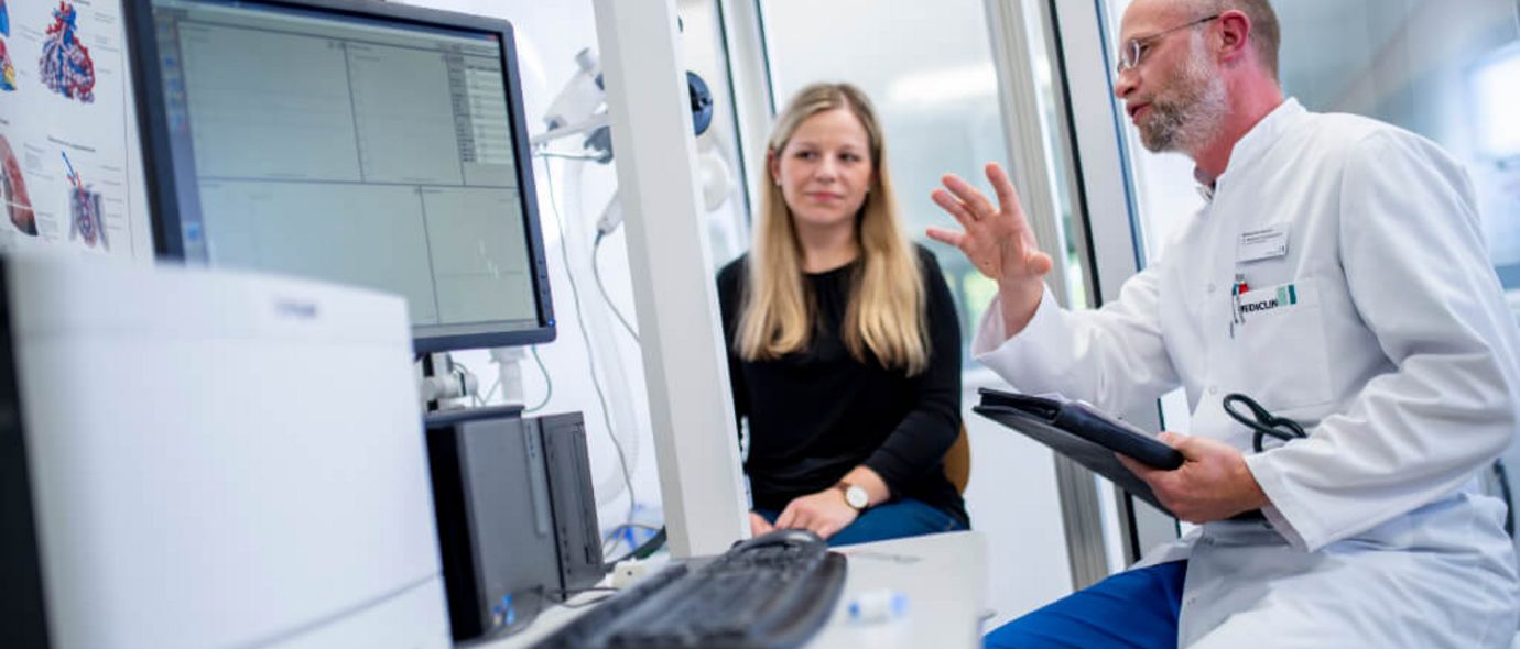 Arzt spricht mit Patientin über die Ergebnisse einer Lungenfunktionsprüfung