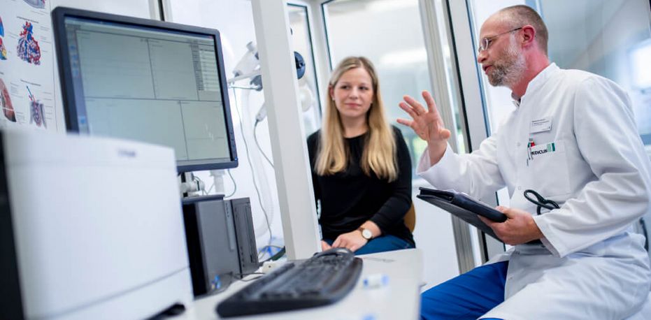 Arzt spricht mit Patientin über die Ergebnisse einer Lungenfunktionsprüfung