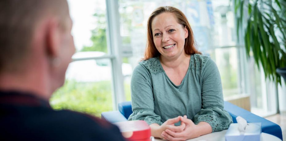 Therapeutin spricht mit einem Patienten in der Einzeltherapie
