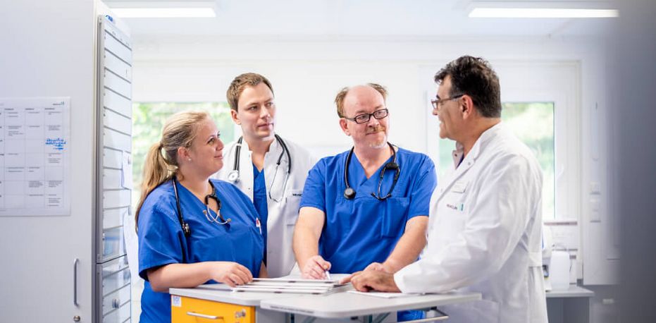 Pflegekräfte und Ärzte besprechen die gemeinsame Visite