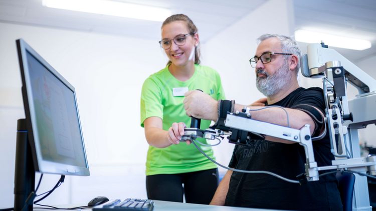 Patient trainiert seinen Arm im Armlabor mit der Armschiene