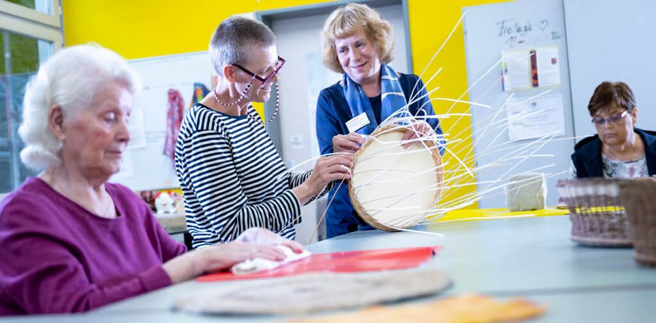 Während des Aufenthalts Patienten flechten einen Korb in der Ergotherapie