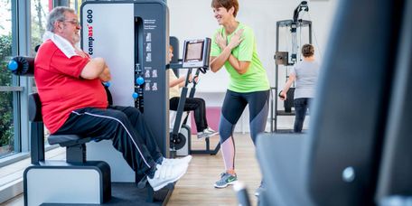 Patient trainiert unter Anleitung an Geräten im MTT-Raum